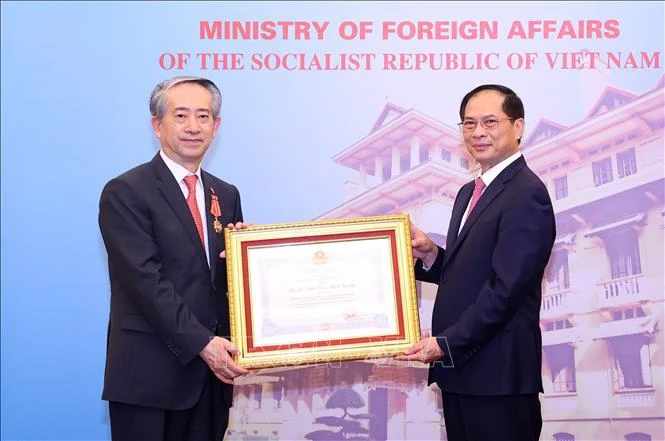 Deputy Prime Minister and Minister of Foreign Affairs Bui Thanh Son (right) presents Friendship Order of the Vietnamese State to Chinese Ambassador Xiong Bo (Photo: VNA)