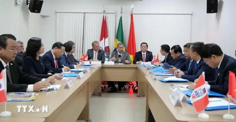 Nguyen Trong Nghia (six from right), Politburo member and Secretary of the Party Central Committee, holds a working session with President of the Democratic Labour Party Carlos Lupin. (Photo: VNA)