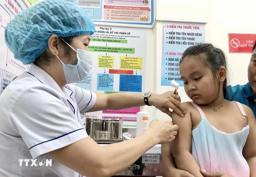 A kid gets measles jab at An Lac ward medical station in Binh Tan district. (Photo: VNA)