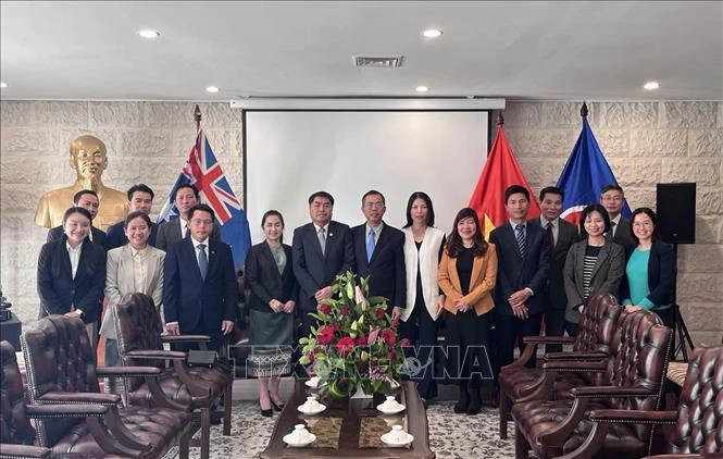 Representatives of the Vietnamese and Lao embassies in Australia pose for a group photo at the event. (Photo: VNA)