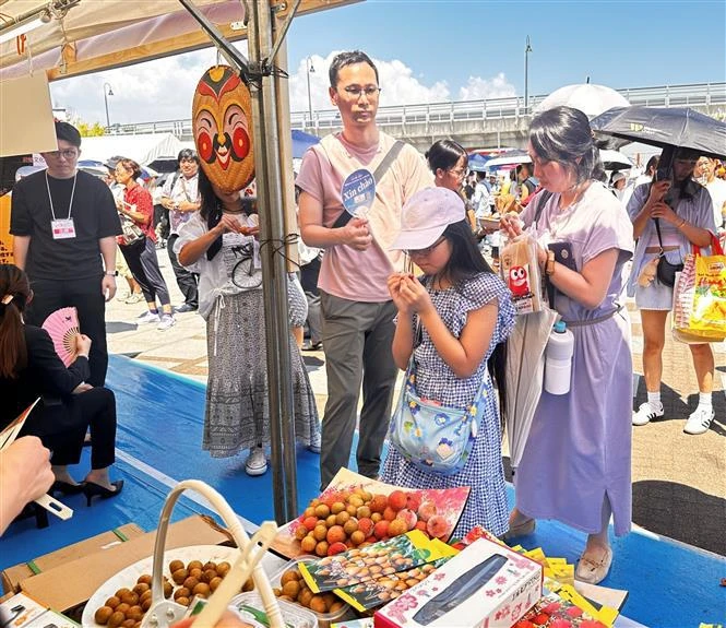 A Japanese family tastes fresh Vietnamese lychees (Photo: VNA)