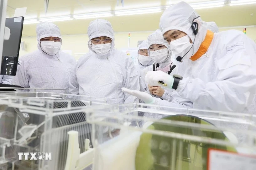 Prime Minister Pham Minh Chinh visits the semiconductor chip production line of Hana Micro Vina Co., Ltd., a Korean-invested firm specialising in semiconductor chip production in Van Trung Industrial Park, Viet Yen district, Bac Giang province (Photo: VNA)