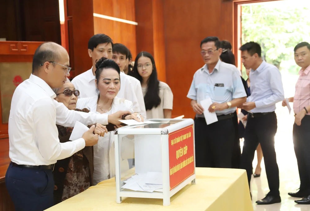 Staff at Vietnamese Embassy in Laos and overseas Vietnamese donate money to support people who have been affected by Typhoon Yagi. (Photo: VNA)