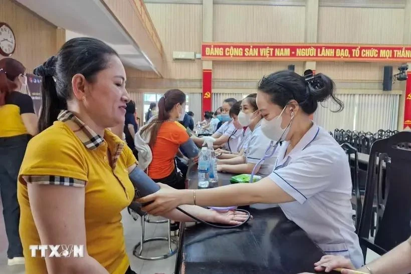 Providing free health check-ups and medicine to workers. (Photo: VNA)