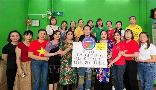 Representatives of the Vietnamese Association in Macau in a group photo with the token of their fund raised for victims of Typhoon Yagi in Vietnam (Photo: VNA)