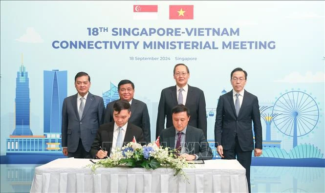 Representatives of the Enterprise Singapore and the Foreign Investment Agency sign decision to set up Singapore Unit at the agency. (Photo: VNA)