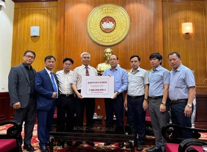 Representatives of the Overseas Vietnamese in Russia hand over 1.5 billion VND to the Vietnam Fatherland Front to support people suffering damage due to Typhoon Yagi in the homeland. (Photo: VNA)