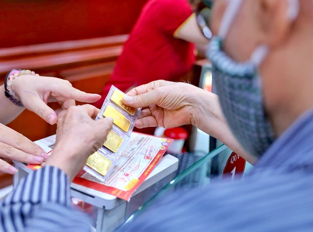 A customer buys gold at Bao Tin Minh Chau Gold's shop in Hanoi. (Photo: VNA)