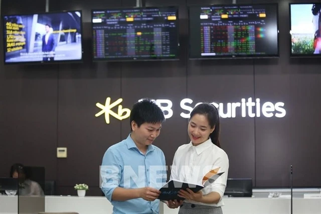 A trader talks to an investor on a trading floor of a securities firm (Photo: VNA)