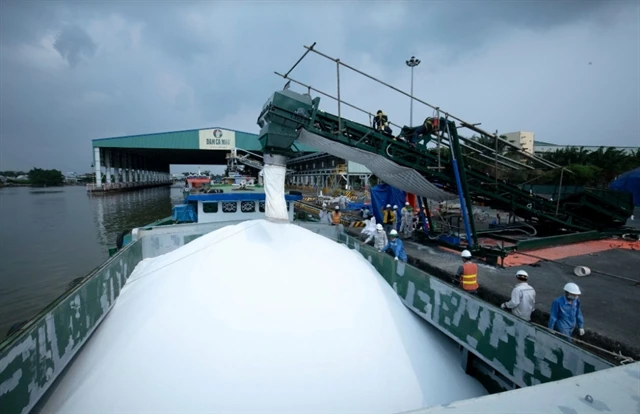 Workers of PetroVietnam CaMau Fertiliser uploading urea on a boat for export. (Photo: pvcfc.com.vn)