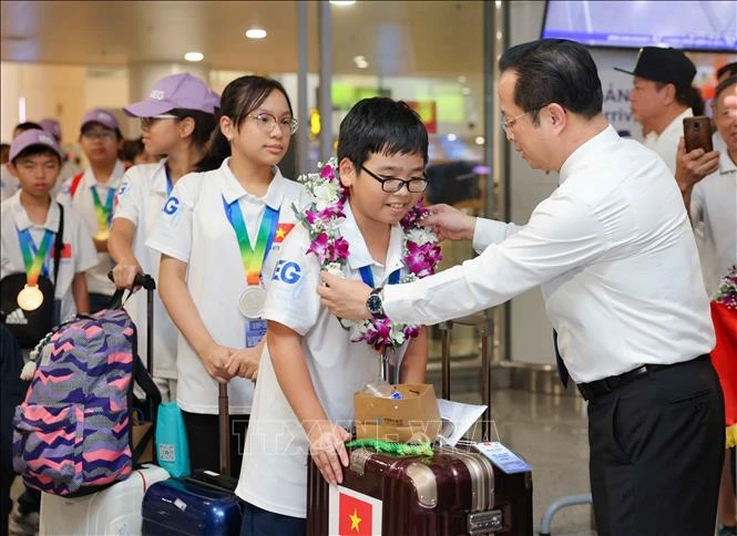 Director of the Hanoi Department of Education and Training Tran The Cuong welcomes the Vietnamese team returning from the 21st IMSO. (Photo: VNA)