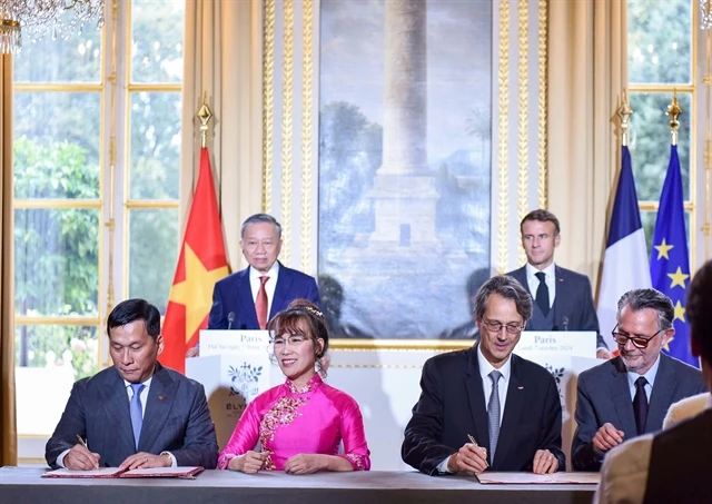 Vietjet Chairwoman Nguyen Thi Phuong Thao (front, 2nd left), Vietjet CEO Dinh Viet Phuong (front, 1st left) and Olivier Andries, President and CEO of Safran (front, 2nd right), Gael Meheust, President and CEO of CFM (front, 1st right), sign the agreement in the presence of Vietnam’s General Secretary and President To Lam (back, left), and French President Emmanuel Macron (back, right). (Photo courtesy of Vietjet)