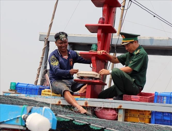 A fishing ship owner and an officer of the Phu Yen provincial Border Guard Command inspect the vessel monitoring system (VMS) on a fishing boat. (Photo: VNA)