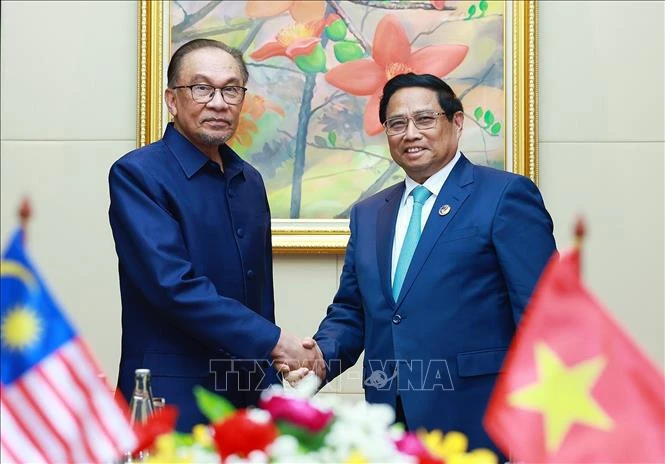 Prime Minister Pham Minh Chinh (R) and his Malaysian counterpart Anwar Ibrahim at their meeting in Vientiane on October 10. (Photo: VNA)