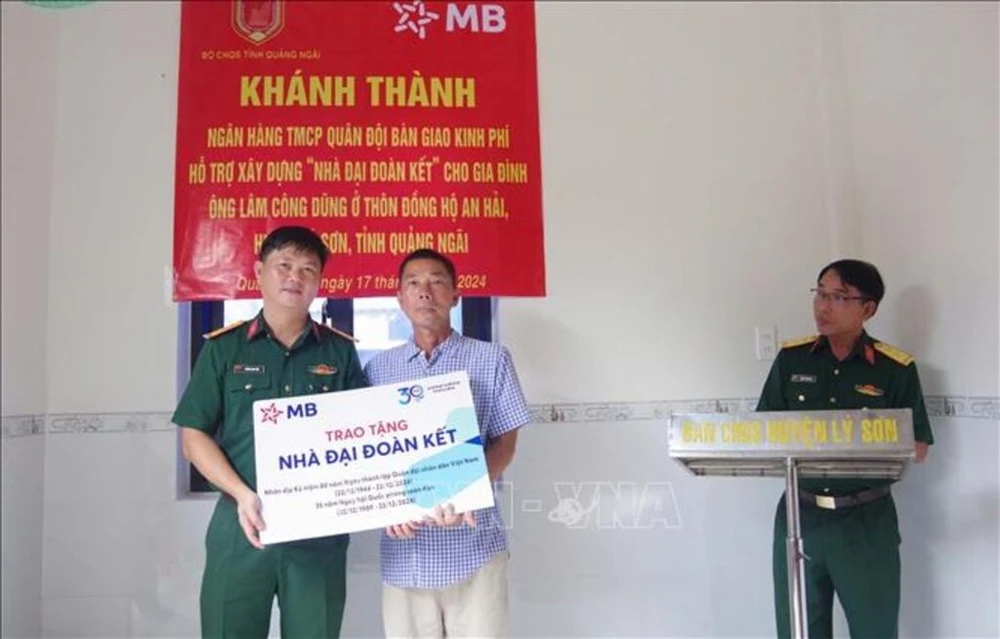 A representative of the Military Command of Ly Son district presents a Great Solidarity house to a poor household in the district's Dong Ho An Hai village in Quang Ngai province. (Photo: VNA)