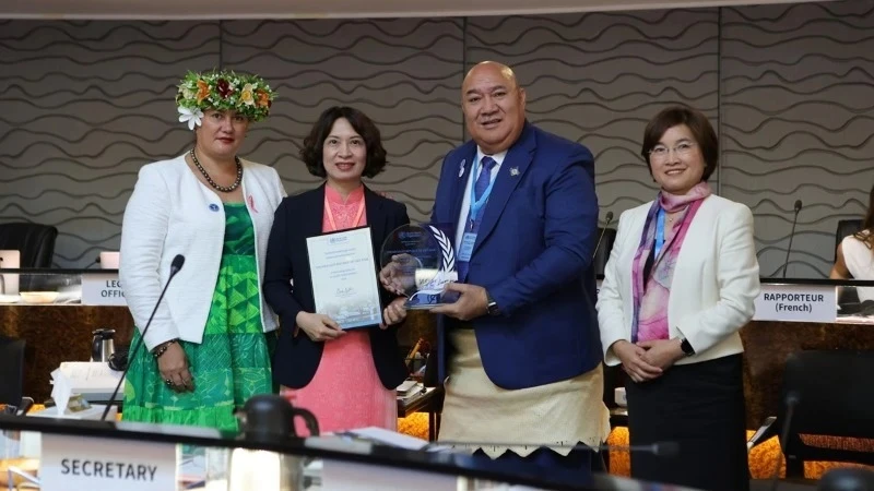 Deputy Minister of Health of Assoc. Prof. Nguyen Thi Lien Huong (2nd from left) receives a certificate and a plaque honouring Vietnam's elimination of trachoma. (Photo: nhandan.vn)