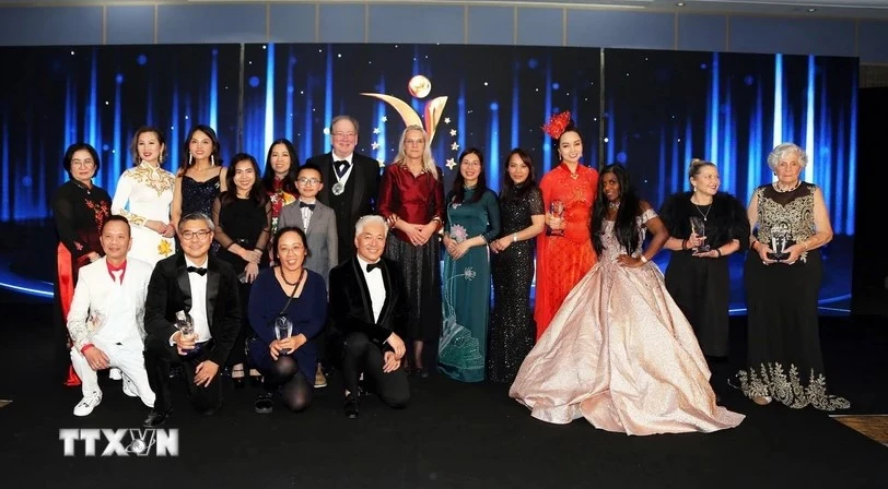 Deputy Ambassador of Vietnam to the UK To Minh Thu (in blue Ao Dai) takes a photo with the award winners. (Photo: VNA)