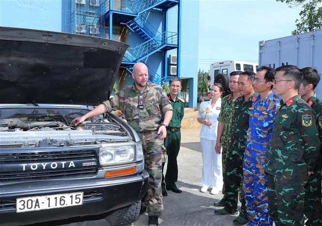 A French expert talks to Vietnamese officers about knowledge and skills in driving, towing, maintaining and servicing four-wheel-drive off-road vehicles. (Photo: VNA)