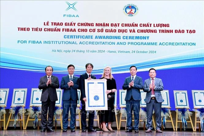 FIBAA General Director Diane Freiberger (third, right) hands over the certificate to the National Economics University (NEU) in Hanoi on October 24. (Photo: VNA)