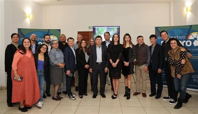 The Vietnamese Embassy delegation take a group photo with typical businesses in Central Mexico. (Photo: VNA)