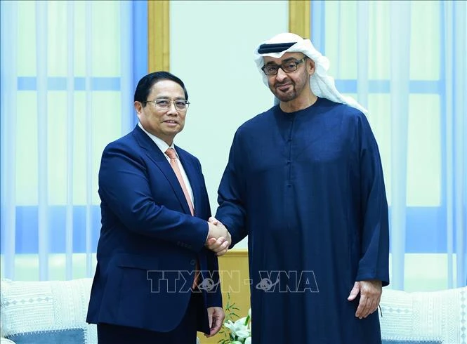 Prime Minister Pham Minh Chinh (L) shakes hands with President of the United Arab Emirates (UAE) Sheikh Mohammed bin Zayed Al Nahyan (Photo: VNA)