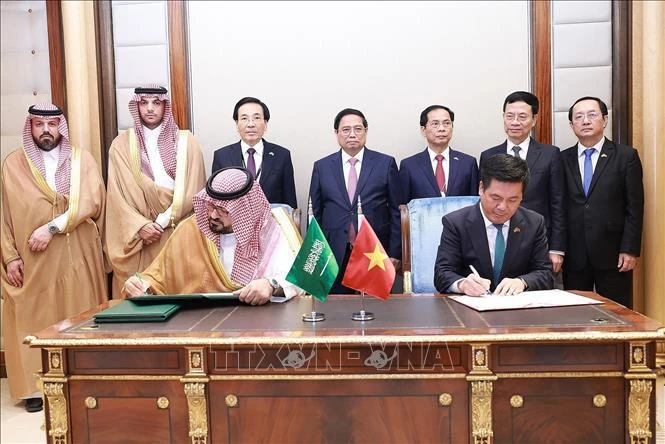 PM Pham Minh Chinh (behind, centre) and officials witness the signing of an MoU on economic and trade cooperation between the Vietnamese Ministry of Industry and Trade and the Saudi Arabian Ministry of Economy and Planning on October 30. (Photo: VNA)