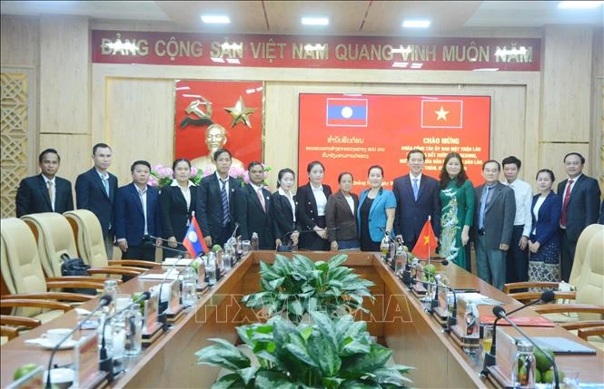 Participants of the two province pose for a group photo at the meeting. (Photo: VNA)