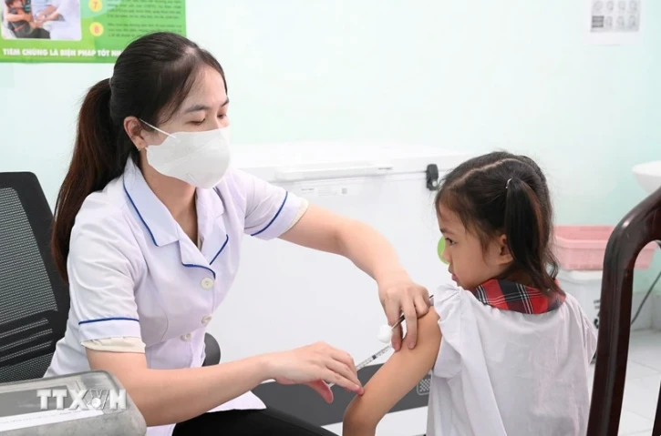 A nurse gives measles vaccine to a pupil. (Phôt: VNA)