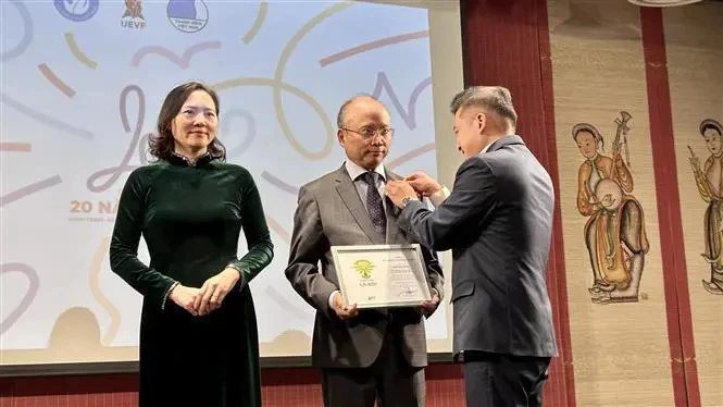 UEVF President Nguyen Phan Bao Thuy presents insignias to Vietnamese Ambassador to France Dinh Toan Thang and Ambassador Nguyen Thi Van Anh (Photo: VNA)