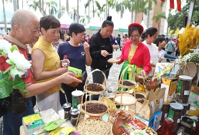 People visit the Vietnamese booth at the festival and try Vietnamese specialties. (Photo: VNA)