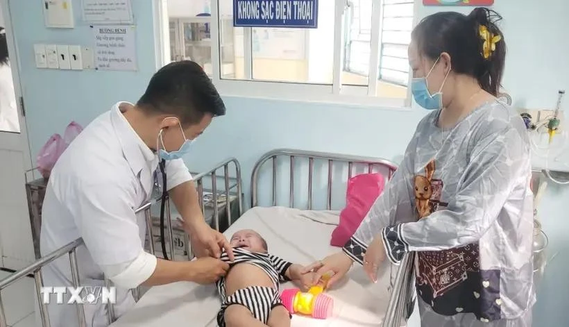 Treating a baby infected with measles (Photo: VNA)