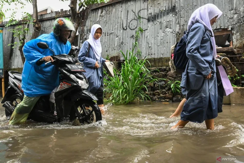 Some students wade through floodwaters on a road in South Tangerang, Banten, on November 11, 2024 (Photo: antaranews)