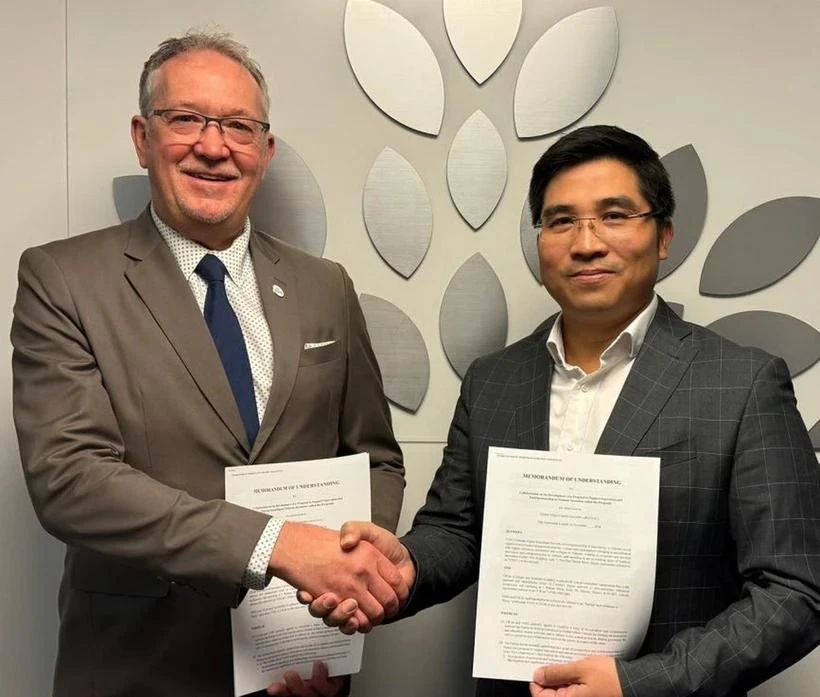 VNEI Chairman Nguyen Trung Dung (R) and CICAN Vice President Alain Roy pose for a photo after signing the cooperation agreement. (Photo: VNA)