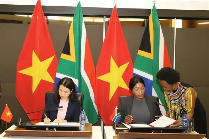 Vietnamese Deputy Foreign Minister Nguyen Minh Hang (L) and South African Deputy Minister of International Relations and Cooperation Anna Thandi Moraka sign the minutes of the 6th meeting of the Vietnam - South Africa Intergovernmental Partnership Forum in Pretoria on November 27. (Photo: VNA)