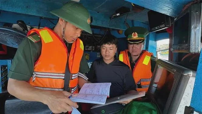 Border guards check documents and procedures before fishing boats leave the port. (Photo:VNA)