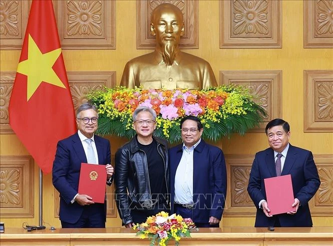 Prime Minister Phạm Minh Chính (second from right) and NVIDIA founder and chief executive officer Jensen Huang (second from left) witness the signing of a cooperation agreement on artificial intelligence research between Vietnamese government and NVIDIA Group. (Photo: VNA)