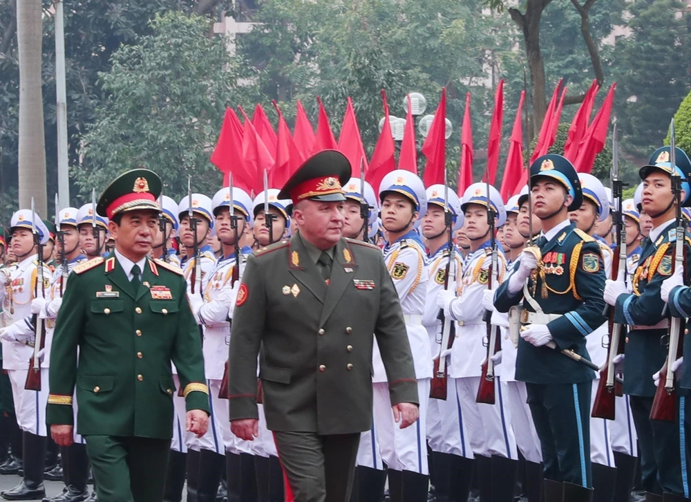 Minister of National Defence Phan Van Giang (left) and his Belarussian counterpart Viktor Gennadievich Khrenin review the guard of honour during the welcoming ceremony in Hanoi on December 17. (Photo: VNA)