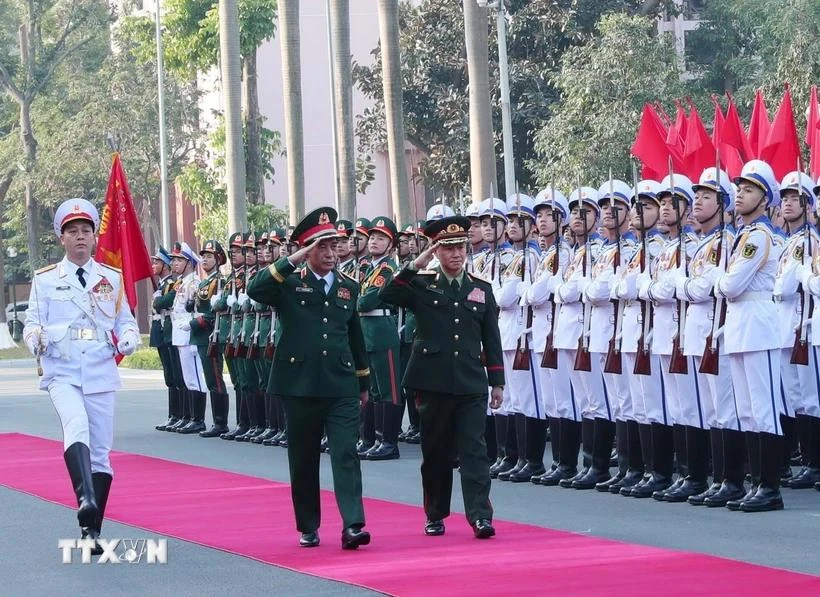 Defence Minister Phan Van Giang (left) and his Lao counterpart Khamliang Outhakaysone review the Guards of Honour on December 18 (Photo: VNA)