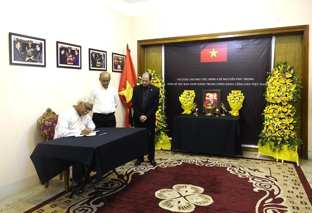 General Secretary of the Communist Party of Bangladesh Ruhin Hossain Prince writes in the condolence book at the respec-paying ceremony held by the Vietnamese Embassy in Bangladesh. (Photo: VNA)