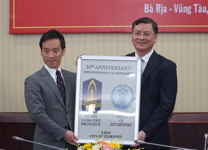 El alcalde de la ciudad de Izumiotsu, Minamide Kenichi (izquierda), entrega un recuerdo por el décimo aniversario de las relaciones entre las dos localidades al vicepresidente del Comité Popular de Ba Ria-Vung Tau, Nguyen Cong Vinh. (Foto: VNA)