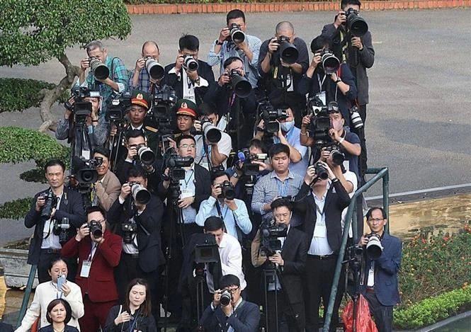 Reporteros participan en la ceremonia de bienvenida al secretario general del Partido Comunista de China y presidente ese país, Xi Jinping, en Hanoi en diciembre de 2023 (Foto: VNA)