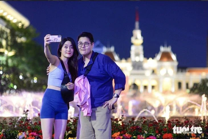 Turistas surcoreanos se toman fotografías de recuerdo en la calle peatonal Nguyen Hue, en Ciudad Ho Chi Minh. (Foto: https://tuoitre.vn/)