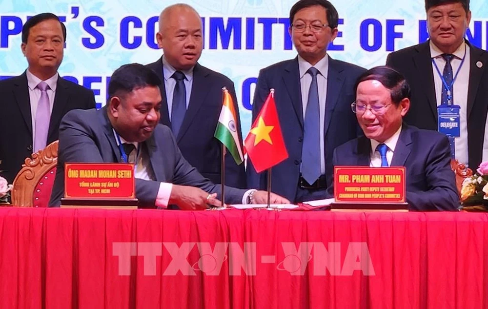 Representantes del Comité Popular de la provincia Binh Dinh y el Consulado General de la India en Ciudad Ho Chi Minh firman un memorando de entendimiento en la conferencia. (Foto: VNA)