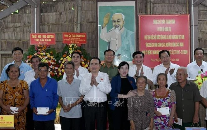 El presidente de la Asamblea Nacional de Vietnam, Tran Thanh Man, junto con las familias beneficiarias de políticas sociales y personas con servicios meritorios en la provincia sureña de Hau Giang. (Foto: VNA)