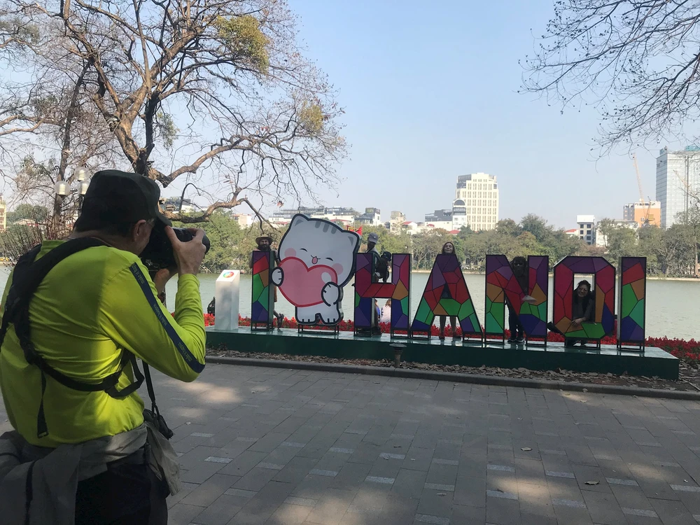 Turistas extranjeros en el lago Hoan Kiem, en Hanoi (Foto: daidoanket.vn)