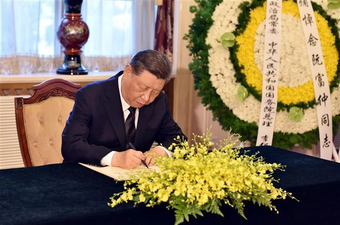 El secretario general del PCCh y presidente de China, Xi Jinping, escribe en el libro de condolencias dedicado al secretario general del PCV, Nguyen Phu Trong. (Foto: VNA)