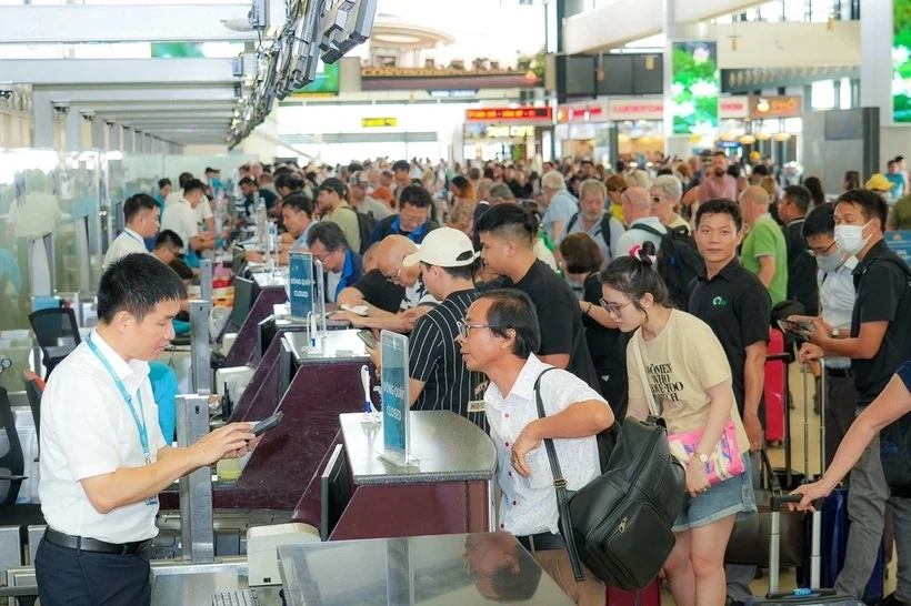 Viajeros completan los procedimientos para embarcar en los aviones en la temporada alta del verano de 2024. (Foto: VietnamPlus)