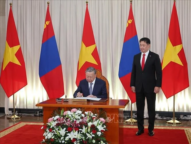 El secretario general del Partido Comunista y presidente de Vietnam, To Lam, firma el libro de invitados de honor (Foto: VNA)