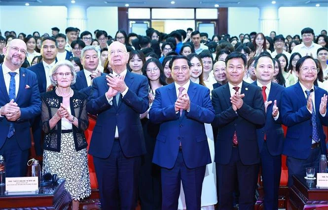 El primer ministro Pham Minh Chinh, el fundador y presidente ejecutivo del FEM, Klaus Schwab, y casi 500 estudiantes de universidades en Hanoi (Foto: VNA)