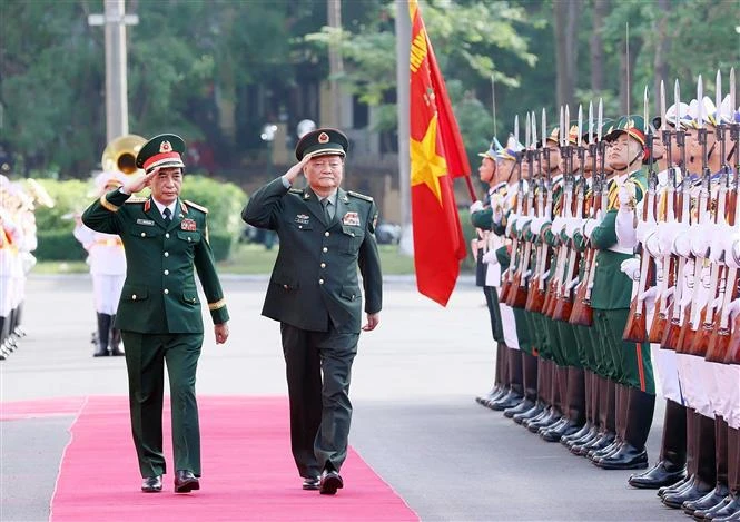 El general Phan Van Giang, subsecretario de la Comisión Militar Central y ministro de Defensa de Vietnam, y Zhang Youxia, vicepresidente de la Comisión Militar Central de China, pasan revista a la guardia de honor (Foto: VNA)